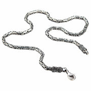 A 4mm sterling silver Byzantine necklace with ornate end caps and a lobster clasp, coiled on a white background.