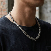 Close-up of a man wearing an 8mm silver Byzantine chain necklace styled in an urban look.