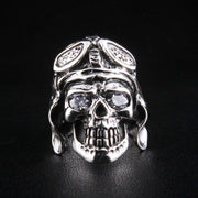 A direct front view of a solid sterling silver German skull ring, clearly showing its sparkling diamond eyes and detailed pilot helmet.