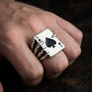 خاتم من الفضة الإسترلينية بتصميم "آس البستوني" ويد هيكل عظمي يرتديه رجل في إصبعه ويظهر حجمه الكبير.