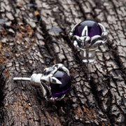 Amethyst claw sterling silver gothic stud earrings featuring a deep purple gemstone held by a detailed silver claw.