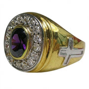Top view of amethyst two-tone gold bishop ring with oval purple stone surrounded by clear accents and silver cross on band
