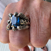 Anello in argento sterling con artiglio d'aquila in topazio blu indossato sulla mano che mostra dettagli di fiamma tribale e pietra preziosa
