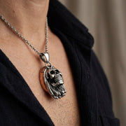 Lähikuva miehestä, joka käyttää Bob Marley -kallokorua, jonka mitat ovat 20mm x 32mm pehmeässä studiovalossa, esittelee eleganttia korvalokuvausta.