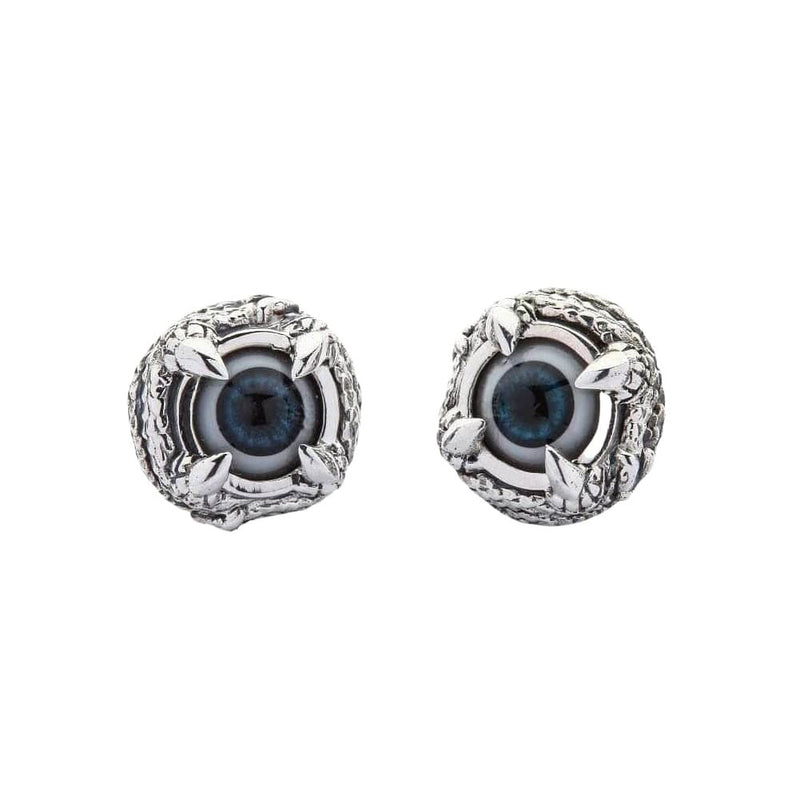 Une paire de boucles d'oreilles clou en argent sterling gothique en forme d'œil de griffes, vue de face montrant le centre en œil bleu et le détail de la monture en argent en forme de griffe.