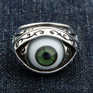 Anillo ojo verde oscuro vista frontal con cabujón de iris detallado y bisel almendrado de filigrana oxidada sobre fondo denim