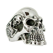 Close-up three-quarter view of a .925 sterling silver skull ring showing detailed teeth, crossbones relief, and oxidized texture