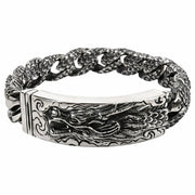 Gros plan sur la sculpture complexe d'une tête de dragon sur un bracelet d'identification en argent