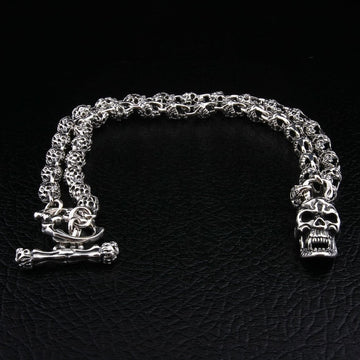 Collana da biker in argento sterling 925 con teschio fiammeggiante, catene a forma di teschio e chiusura a barra T su sfondo in pelle nera.