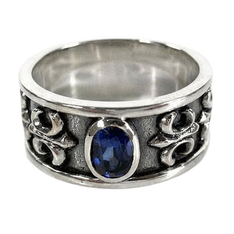 Sterling silver men's band ring featuring a central sapphire-blue oval stone and textured fleur-de-lis side details.