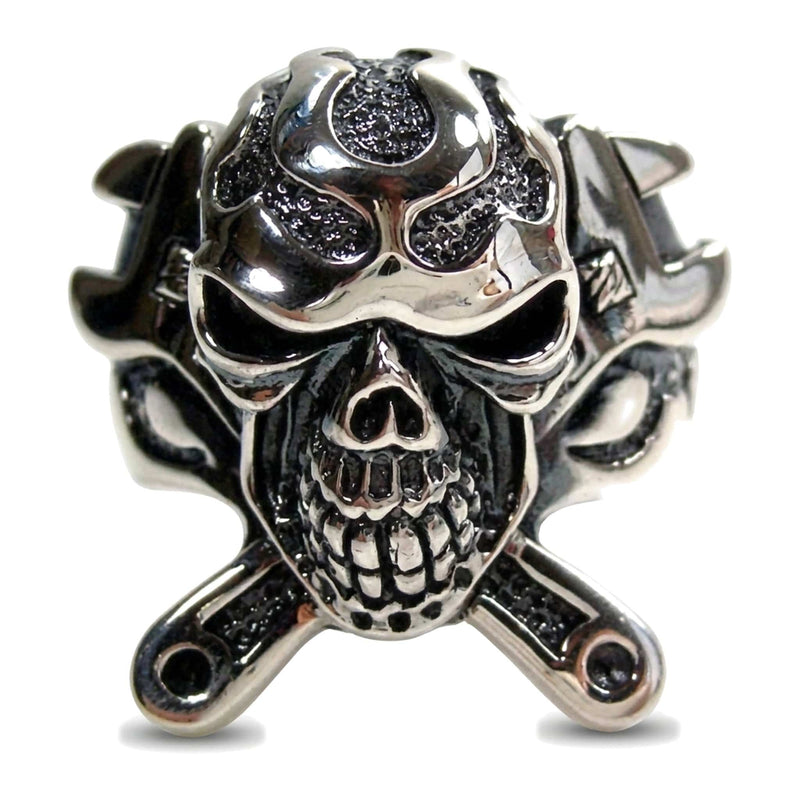 Front of the skull face with crossed wrench handles beneath the jaw and eye sockets cut deep enough to hold shadow