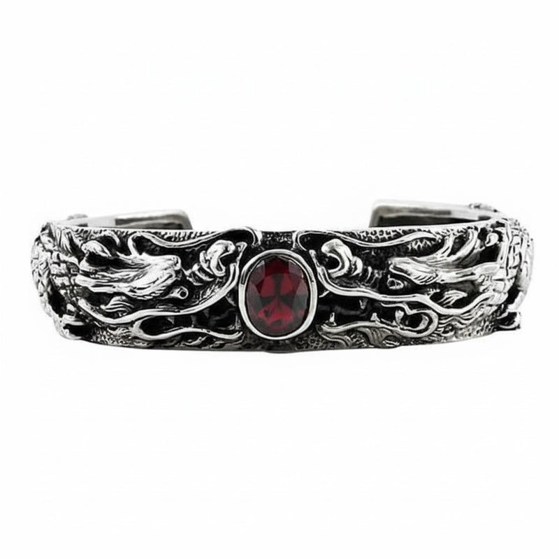 Ein schweres Armband aus Sterlingsilber mit zwei aufwendig gearbeiteten Drachen, die einen ovalen roten Granatstein in der Mitte bewachen.