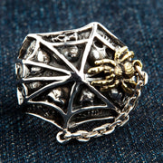 A front view of the goth spider web ring in sterling silver, showing the gold-plated spider and hidden skulls.