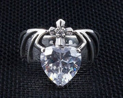 A front view of the gothic Claddagh ring in sterling silver, showing the heart stone, claw hands, and a cross with a small clear stone.