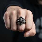 Man som bär en gotisk sköldring i sterlingsilver med en granat CZ-sten på långfingret och visar knytnävepose.