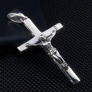 The handcrafted solid silver Jesus cross pendant displayed on a black textured surface, highlighting its high-polish finish.