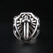 A front view of the heavy sterling silver knight sword and shield ring on a black leather background.