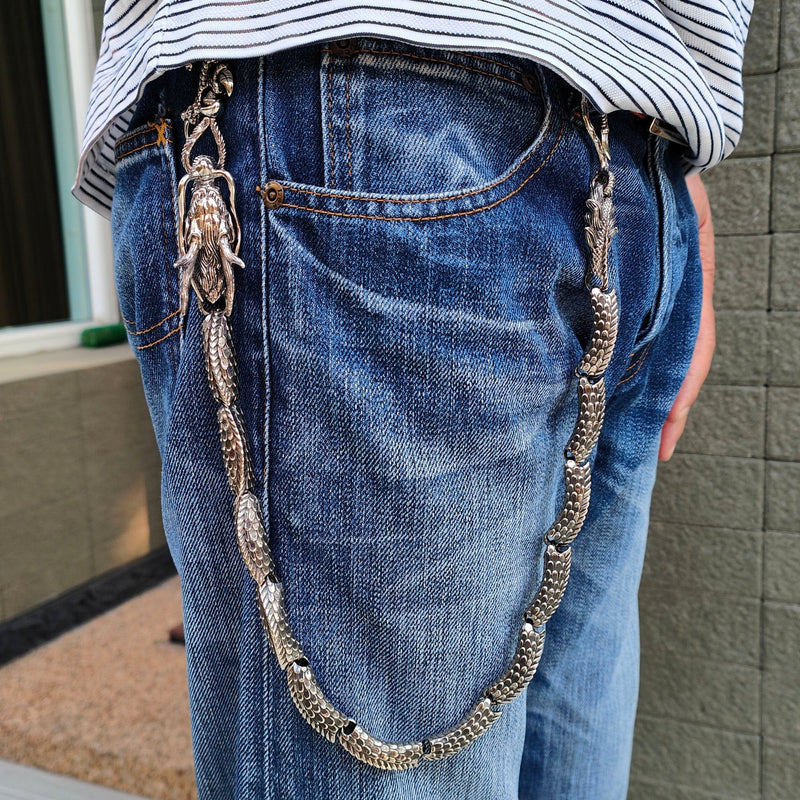 A man wearing a heavy, 253-gram ruby eye dragon wallet chain, demonstrating its impressive size and style with blue jeans.