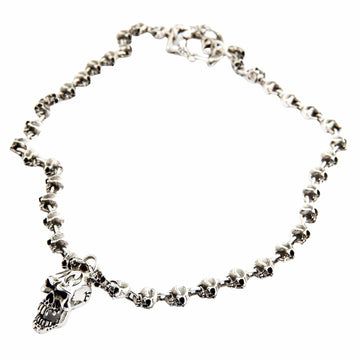 A heavy sterling silver skull link necklace with a large central pendant, laid out in a coil on a white background.
