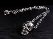 A heavy sterling silver skull necklace with a 7mm biker chain and T-bar clasp laid out on a black surface.
