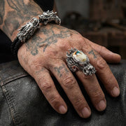 En man's hand som bär den tunga silverdraktringen, som visar dess imponerande storlek och den unika Shivaösten.