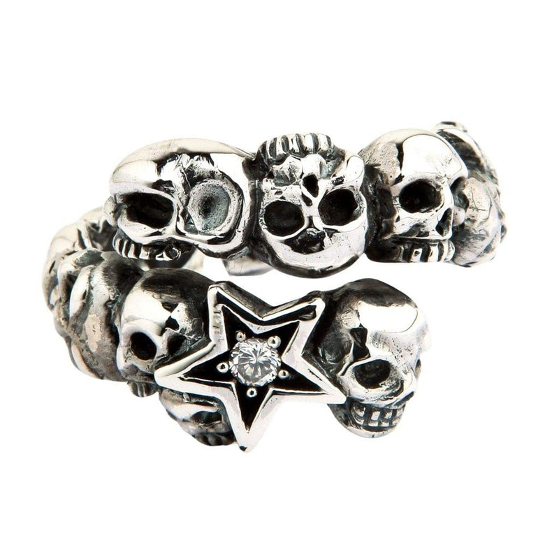 Toma de estudio frontal del anillo envolvente en plata .925, que destaca su diseño de calaveras escalonadas y la estrella central con piedra facetada.