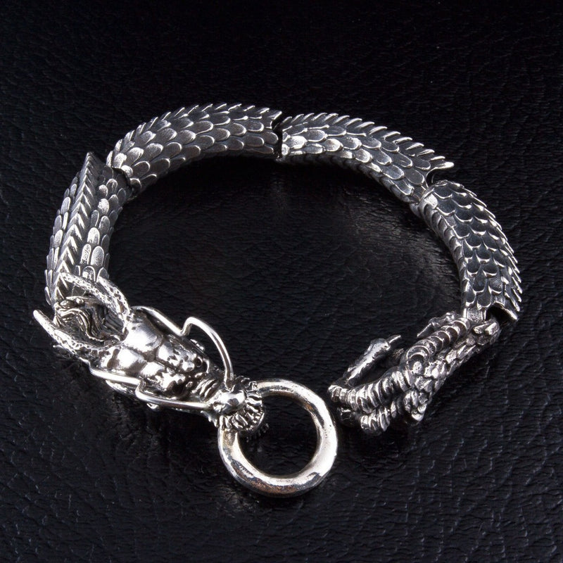 Japanisches Armband aus Sterlingsilber mit zwei Drachenkopfverschlüssen auf schwarzem Lederhintergrund