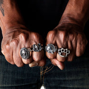 A solid sterling silver knuckle duster ring being worn on a clenched fist, showcasing its bold and powerful design.