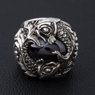 Anillo de pez koi en plata de ley con cabujón de ónix negro, vista frontal que muestra dos peces entrelazados