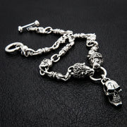 獅子與骷髏 925 純銀騎士項鍊,配有雙獅頭與懸掛骷髏墜飾,黑色皮革背景。