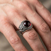 एक व्यक्ति ने गॉथिक शैली की कामदेव की प्रेम अंगूठी पहन रखी है, जो इसके विशाल आकार को प्रदर्शित करती है।