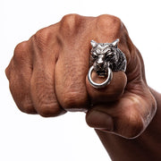 A man's hand wearing a collection of heavy biker rings, with the guardian tiger ring featured.