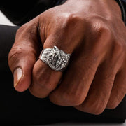 A man's hand wearing the heavy silver owl band ring, demonstrating its bold statement size.