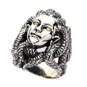 Vue de face de la bague Méduse en argent sterling avec yeux en oxyde de zirconium jaune et détails de serpents enroulés.