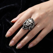 A close-up of a female hand modeling a large gothic-style Medusa ring with a 22mm by 33mm face size under soft studio lighting.