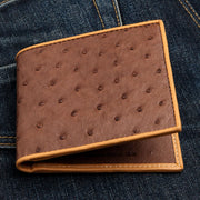 A men's bifold wallet in genuine brown ostrich leather, showing the distinctive full-quill pattern.