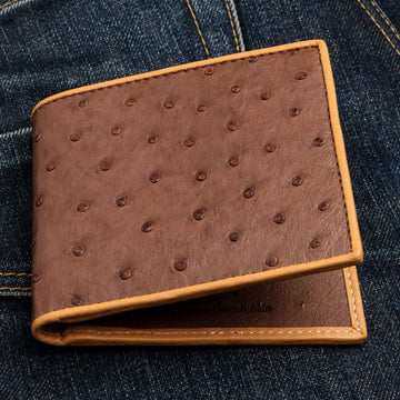 A men's bifold wallet in genuine brown ostrich leather, showing the distinctive full-quill pattern.