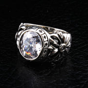 A men's solid sterling silver ring featuring a large white topaz and a band carved with a gothic floral cross.