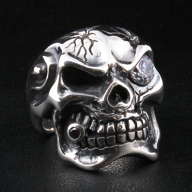 Un anello solido in argento sterling a forma di teschio della mafia crepato con un grande occhio CZ con zaffiro chiaro.