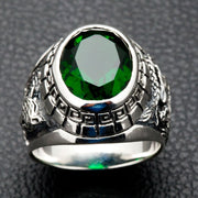 A men's dragon and tiger ring, handcrafted from sterling silver with a large faceted green emerald stone.