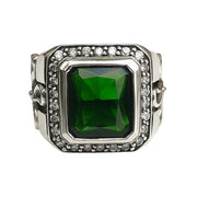 A men's solid sterling silver gothic cross ring, featuring a large green emerald CZ stone and a halo of clear accents.
