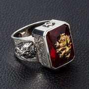A men's solid silver signet ring featuring a golden brass rampant lion emblem on a large red stone.