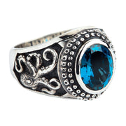 A men's solid sterling silver ring featuring carved octopus tentacles and a large, faceted London Blue Topaz.