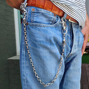 A man wearing the heavy tribal skull biker chain, showing how it hangs from the belt loop of his jeans.