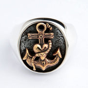 Anel de sinete com âncora masculino visto de cima, mostrando o detalhado trabalho em latão da âncora e do coração.