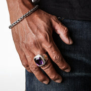 A man wearing the large sterling silver Amethyst Bishop Ring to show its scale and statement style on the hand.