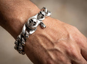 Man wearing heavy sterling silver multi skull curb bracelet on wrist