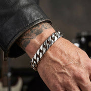 Těžký pánský stříbrný řetízek 70g nošený na tetovaném zápěstí s koženou bundou