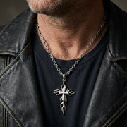 Man wearing sterling silver flame cross pendant on a chain with leather jacket