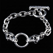 Full view of the men's silver skull bracelet showing the heavy chain links and T-bar clasp.